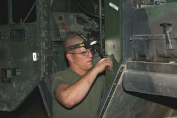 Sergeant Jeffery S. Perez, Marine Corps Technical Assistance Team, Marine Corps Systems Command, Albany, Ga., and a member of the AIT here, works towards completing the installation of the MAK to a LVS here Oct. 1.
