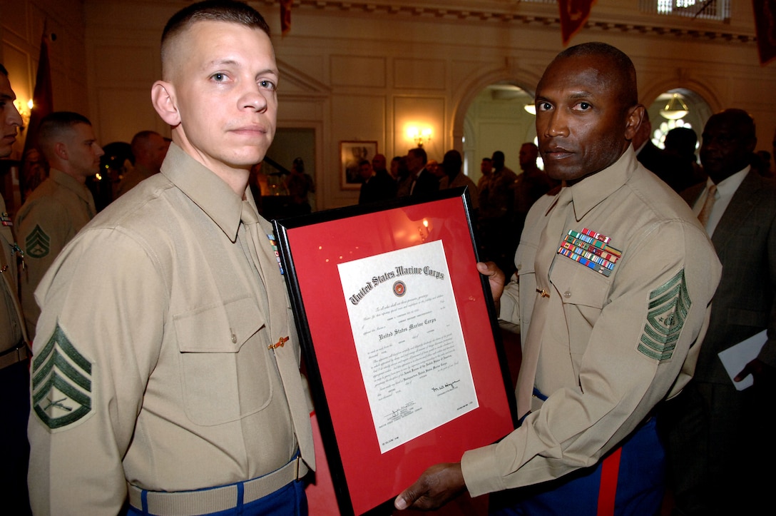 Gunnery Sgt. Shawn C. Corcoran, left, from the 9th Marine Corps Recruiting District, was promoted by the Sergeant Major of the Marine Corps, Sgt. Maj. John L. Estrada, during the Commandant of the Marine Corps? Combined Service Awards ceremony held Nov 1, at Harry Lee Hall in Quantico, Va.  Corcoran was selected by a board of senior enlisted Marines from the Marine Corps Recruiting Command as the 2005 Recruiter of the Year for the Marine Corps.