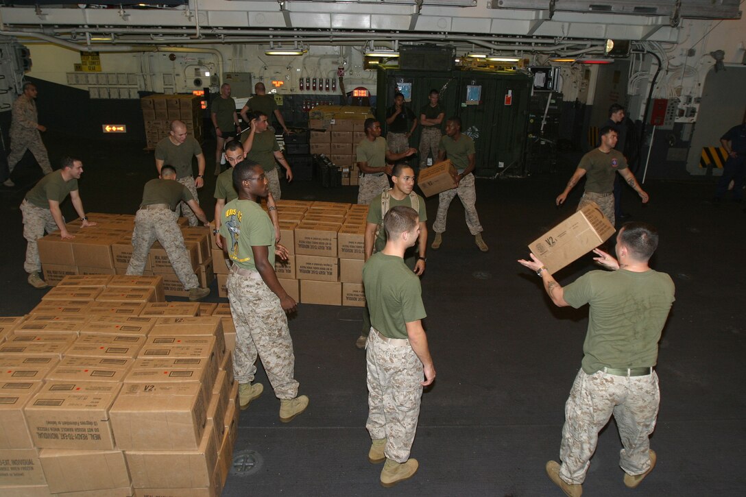 Marines with the 15th Marine Expeditionary Unit (Special Operations Capable) prepared hundreds of cases of Meals Ready to Eat to hand out to victims of the recent catastrophic tsunami in the Indian Ocean.