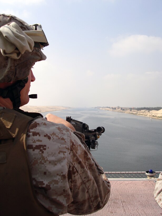 A MArine stands watch on the flight  deck of the USS Iwo Jima while the ship passes passes through the Suez Canal on July 4.  (U.S. Marine Corps Photo by GySgt Frank)
