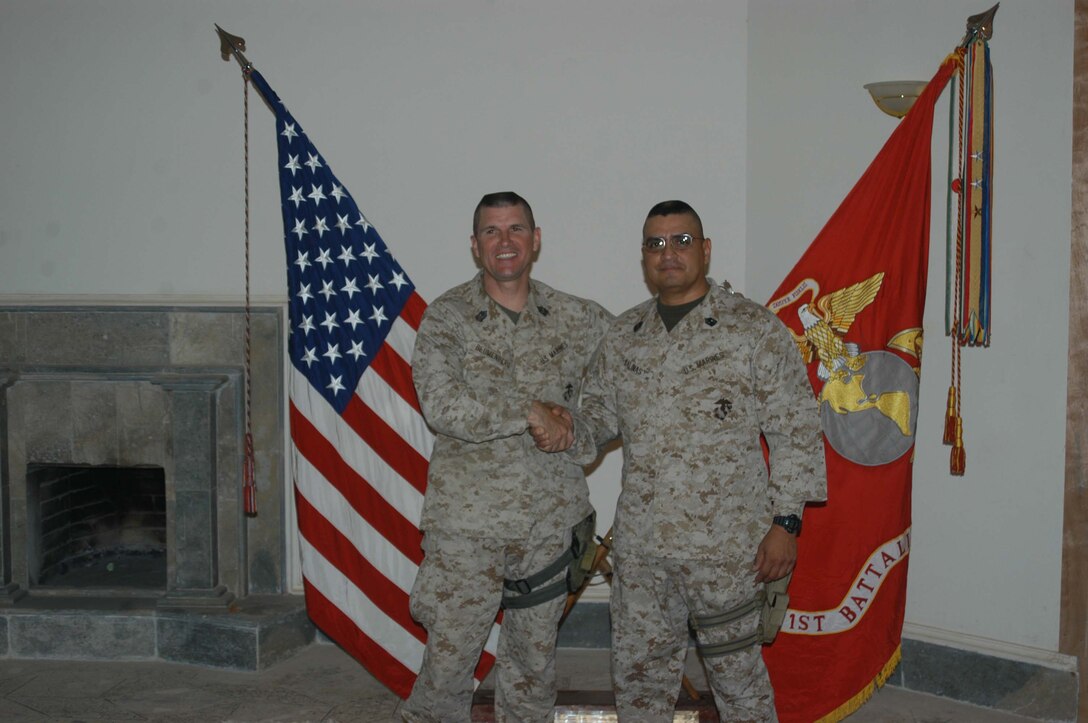 CAMP HURRICANE POINT Ar Ramadi, Iraq (May 1, 2005) -Sergeant Major Charles T. Blumenburg,(left) battalion sergeant major, 1st Battalion, 5th Marine Regiment, shakes hands with newly promoted Master Gunnery Sgt. Roland Salinas after a ceremony here. The 42-year-old operations chief with Headquarters and Service Company and San Antonio, Texas, native reached the final rung on the Marine Corps' ladder of success for enlisted personnel when he was promoted to the rank of master gunnery sergeant after serving more than 24 years. Salinas reenlisted in Iraq and has three years left on his twilight contract. Photo by Cpl. Tom Sloan