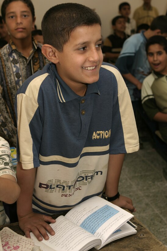 FALLUJAH, Iraq - An Iraqi schoolchild smiles as he observes local soldiers hanging up a blackboard at his school here May 2.  Iraqi Security Forces and Marine forces here visited local schools to distribute blackboards, school desks, and writing supplies as part of the ongoing joint civil-military mission, "Operation Blackboard."