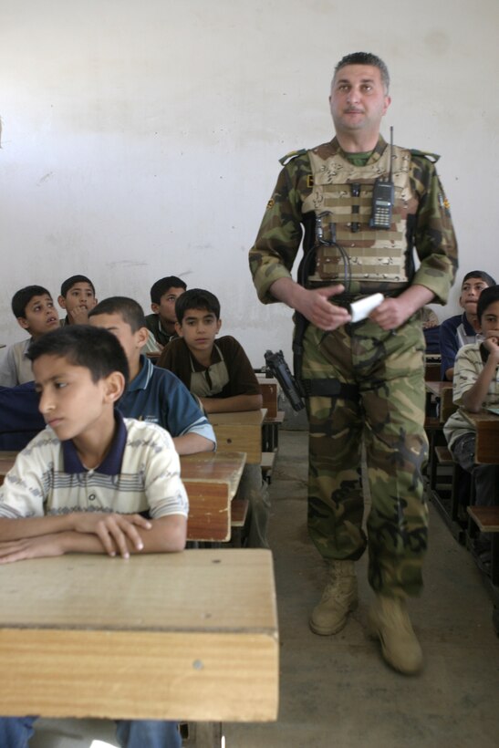 FALLUJAH, Iraq - Iraqi Maj. Laith Jabbar Al Tememey, company commander for 1st Company, 1st Battalion, 2nd Brigade, Iraqi Security Forces, walks amongst a class of children at a school here May 2 after helping hang a new chalkboard.  Iraqi Security Forces and Marine forces here visited local schools to distribute blackboards, school desks, and writing supplies as part of the ongoing joint civil-military mission, "Operation Blackboard.