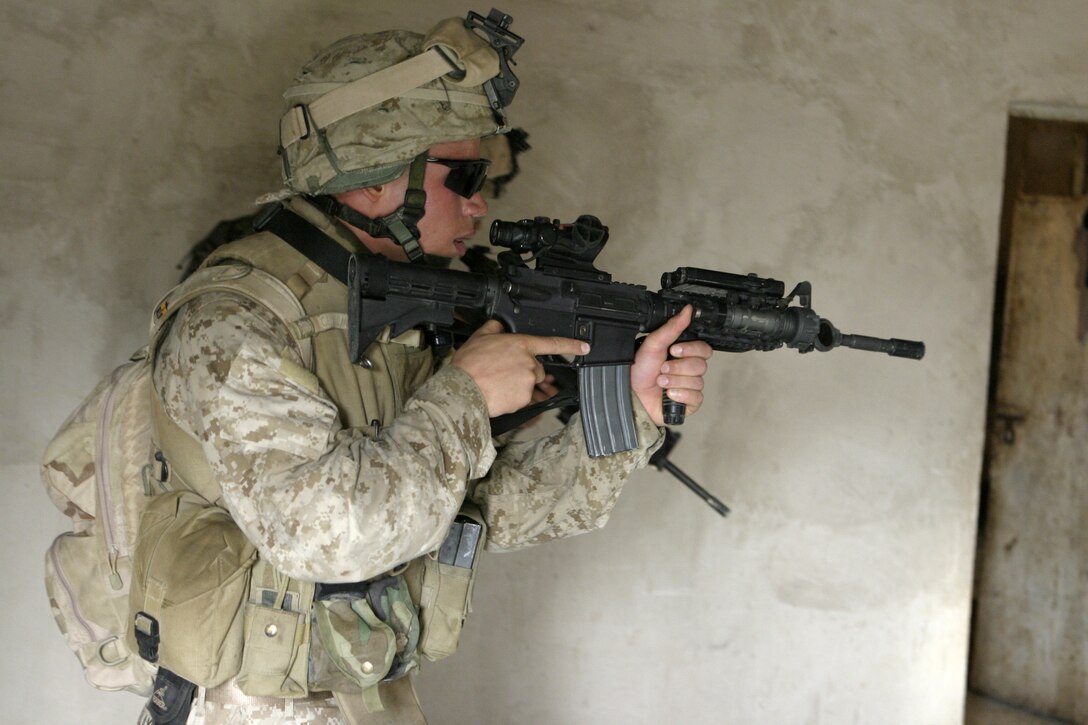 ASRAGIYAH, Iraq - Cpl. Tony Blaylock, a squad leader with 4th Platoon, Company C, 1st Battalion, 6th Marine Regiment, sweeps a house here June 2 as he looks for weapons and insurgents.  Company C personnel worked alongside Iraqi soldiers to sweep through the farming community outside Fallujah and confiscate several AK-47 assault rifles.