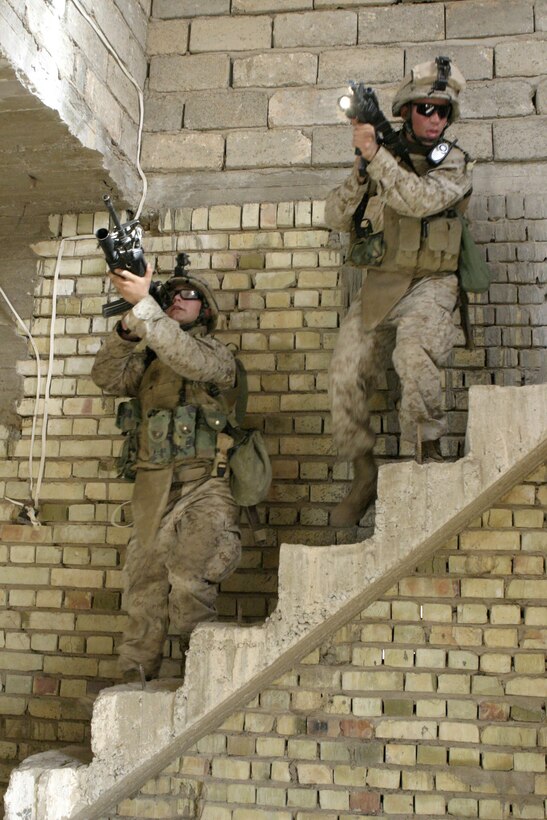 ASRAGIYAH, Iraq - Two Marines with 4th Platoon, Company C, 1st Battalion, 6th Marine Regiment search through a house here June 2 during 'Operation Hard Knock.'  Company C personnel worked alongside Iraqi soldiers to sweep through the farming community outside Fallujah and confiscate several AK-47 assault rifles.