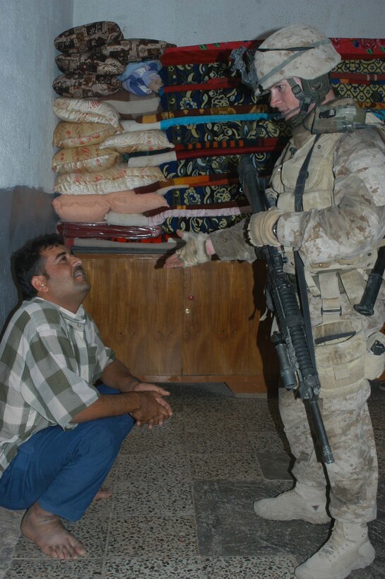 AR RAMADI Iraq (July 2, 2005)  -- Corporal Andrew D. Litz, a rifleman and the squad leader of 2nd Squad, 1st Platoon, Company A, 1st Battalion, 5th Marine Regiment, questions an Iraqi man inside his home during a mission in the city here July 2. The 24-year-old from Plano, Texas, and fellow Company A Marines conducted a raid in the Al Anbar capital between midnight and 5 a.m. and apprehended three insurgents. Photo by: Cpl. Tom Sloan