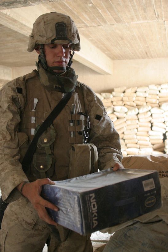 HIT, Iraq (July 2, 2005)- Lance Cpl. Bradley S. Bodkin, 21, a mortar man from Morgantown, W.Va., with Company K, 3rd Battalion, 25th Marine Regiment, Regimental Combat Team-2 finds six boxes of phones believed to be used to make improvised explosive devices hidden in cement bags at the Marines firm base in the city during Operation Guardian Sword conducted to clear the city and set-up Iraqi Security Forces firm bases through out the city. (Official USMC photo by Lance Cpl. Lucian Friel (RELEASED)