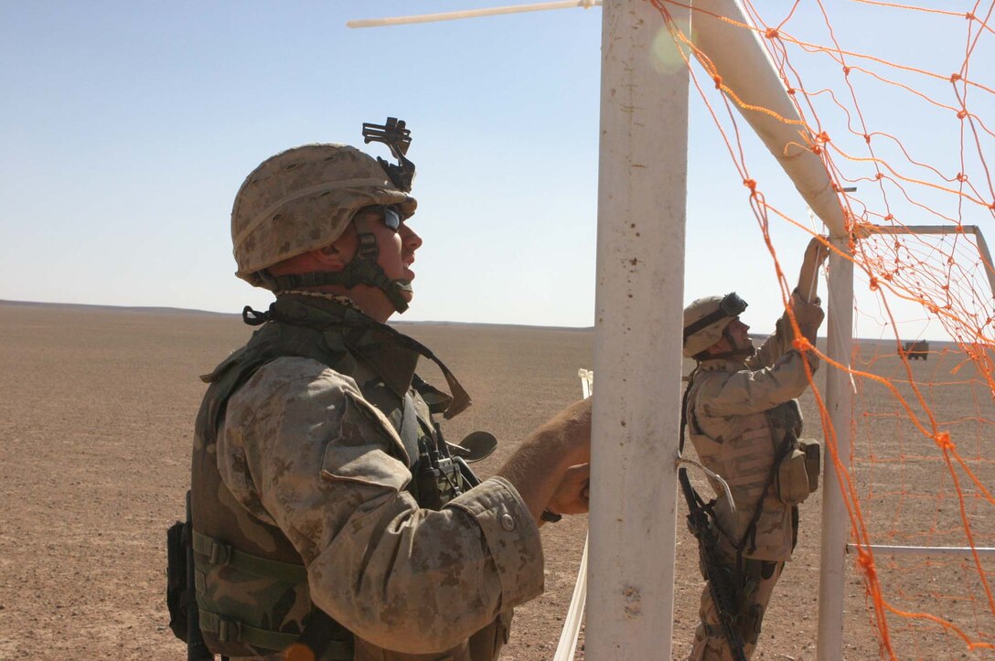 Cpl. Jeffrey H. Meighen, Civil Affairs Non-commissioned Officer, 5th Civil Affairs Group (CAG), 2d Light Armored Reconnaissance Battalion, Regimental Combat Team-2, gets the chance to make a difference in Iraqi children's lives during Operation Iraqi Freedom by handing out toys and hygiene products, participating in sporting events and helping to rebuild their towns. Meighen puts a net on a soccer goal for a game between the Marines and children from a local village.(Photo by LCpl. Zachary W. Lester)