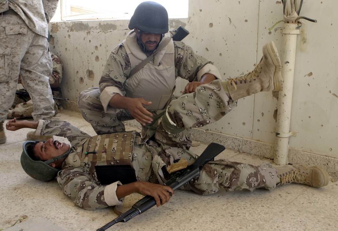 FALLUJAH, Iraq - An Iraqi soldier practices bandaging his fellow troop during a training evolution 1st Battalion, 6th Marine Regiment's Iraqi Security Forces training cadre personnel supervised here August 2.  Since mid-March, battalion personnel have trained approximately 600 Iraqi personnel on topics such as first aid in combat, infantry tactics, and convoy driving skills.  Iraqi forces are fully integrated into every operation the battalion's Marines and sailors conduct in and around the city.