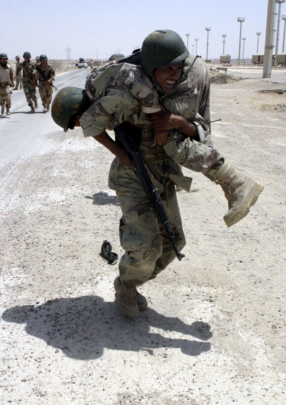 FALLUJAH, Iraq - An Iraqi soldier carries a troop feigning injury to safety during a training evolution 1st Battalion, 6th Marine Regiment's Iraqi Security Forces training cadre personnel supervised here August 2.  Since mid-March, battalion personnel have trained approximately 600 Iraqi personnel on topics such as first aid in combat, infantry tactics, and convoy driving skills.  Iraqi forces are fully integrated into every operation the battalion's Marines and sailors conduct in and around the city.
