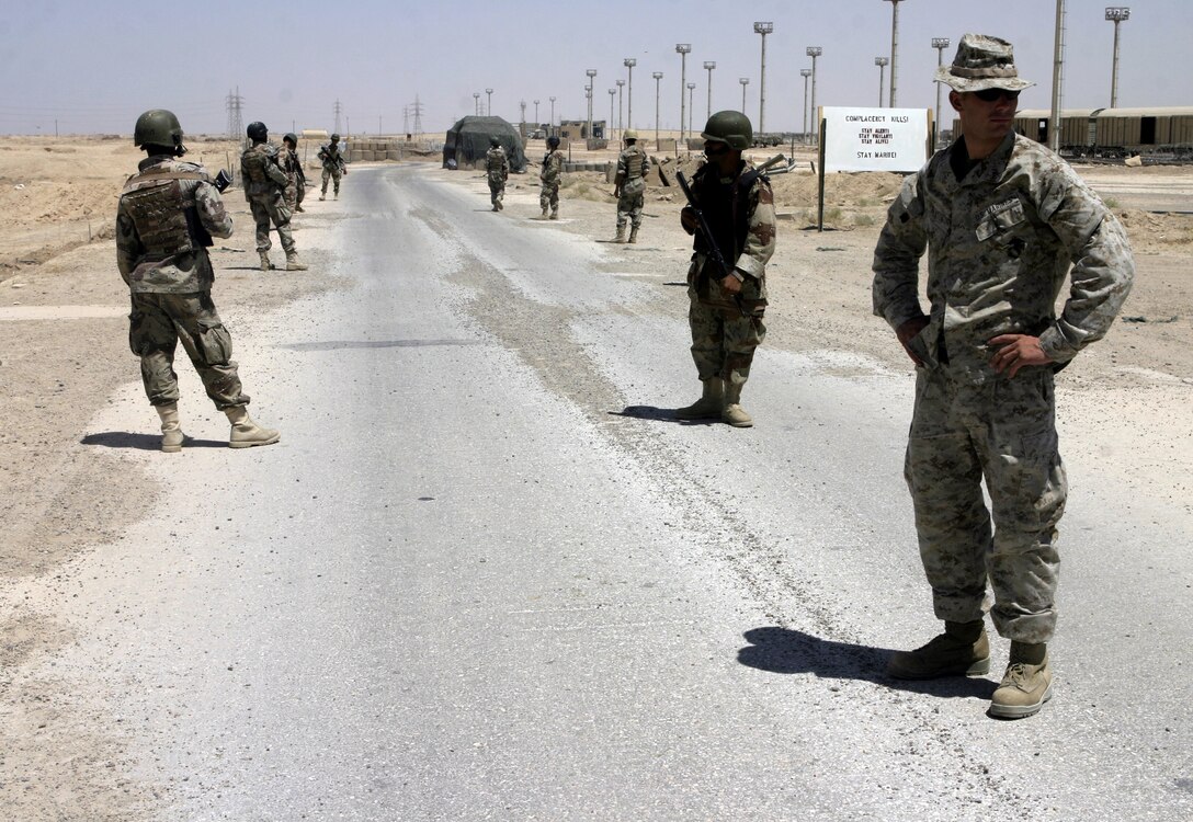 FALLUJAH, Iraq - Lance Cpl. Peter Benson, an instructor with 1st Battalion, 6th Marine Regiment's Iraqi Security Forces training cadre, supervises Iraqi soldiers and policemen conduct a patrol during a field exercise here Aug. 2.  Since mid-March, battalion personnel have trained approximately 600 Iraqi personnel on topics such as first aid in combat, infantry tactics, and convoy driving skills.  Iraqi forces are fully integrated into every operation the battalion's Marines and sailors conduct in and around the city.