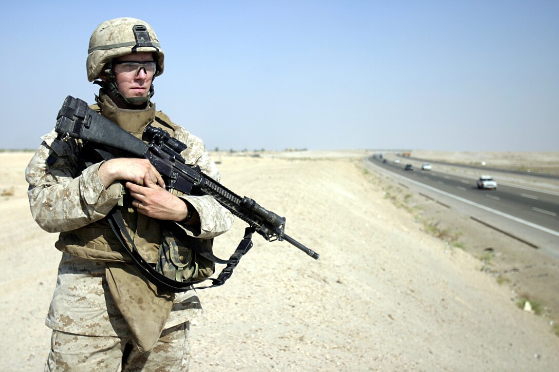 FALLUJAH, Iraq - Corporal Joseph Mahoney, a machine gunner and vehicle operator with 4th Combined Anti-Armor Team, Weapons Company, 1st Battalion, 6th Marine Regiment, observes for insurgent activity along Fallujah's Route Mobile during a recent mission.  The 21-year-old Lynn, Mass. native and his 22 fellow Marines with team "Ghost rider" provide security for the area by patrolling Fallujah's streets and observing for terrorists placing improvised explosive devices along the surrounding roads.