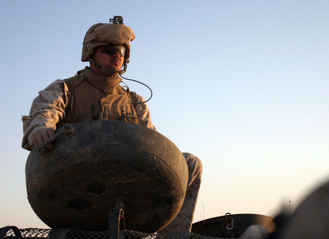 AL QA'IM, Iraq (Sept. 2, 2005) -- Peidmont, Ala., native Staff Sgt. Timothy P. Hanson, platoon sergeant, 2nd Platoon, Company K, 3rd Battalion, 2nd Marine Regiment, 2nd Marine Division stands in the track commander hatch of an amphibious assault vehicle during a cordon and knock mission conducted here at a local cement factory.  (Official U.S. Marine Corps photo by Sgt. Jerad W. Alexander)