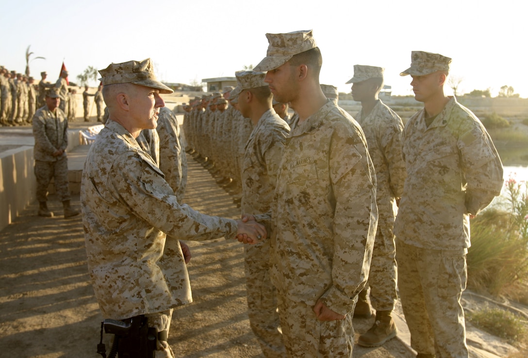 CAMP BAHARIA, Iraq - Major General Richard Huck, 2nd Marine Division's commanding general, shakes hands with 1st Battalion, 6th Marine Regiment personnel during a reenlistment ceremony here Oct. 2.  Altogether, the 45 personnel reenlisting received approximately one million dollars in reenlistment bonuses, along with future duty station preferences.