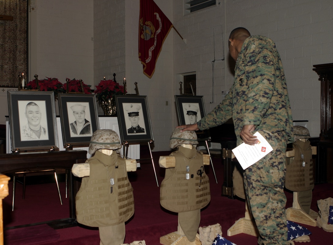 MARINE CORPS BASE CAMP LEJEUNE, N.C. - A sailor with 1st Battalion, 6th Marine Regiment pays his final respects to his four fallen comrades after the unit's memorial service here Dec. 2.  First Battalion, Sixth Marine Regiment and 2nd Combat Engineer Battalion personnel had gathered at the Main Protestant Chapel here to commemorate the lives of Lance Corporals Andrew Kilpela, Mario Castillo, Joshua Klinger and 'Doc' Aaron Kent.  The four service members were killed by improvised explosive devices during the unit's deployment to Iraq from March through October.