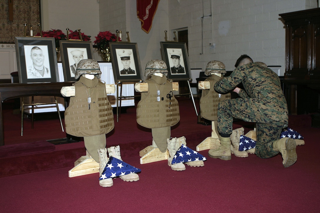 MARINE CORPS BASE CAMP LEJEUNE, N.C. - A Marine with 2nd Combat Engineer Battalion pays his final respects to his four fallen comrades after a memorial service here Dec. 2.  First Battalion, Sixth Marine Regiment and 2nd CEB personnel had gathered at the Main Protestant Chapel here to commemorate the lives of Lance Corporals Andrew Kilpela, Mario Castillo, Joshua Klinger and 'Doc' Aaron Kent.  The four service members were killed by improvised explosive devices during the unit's deployment to Iraq from March through October.