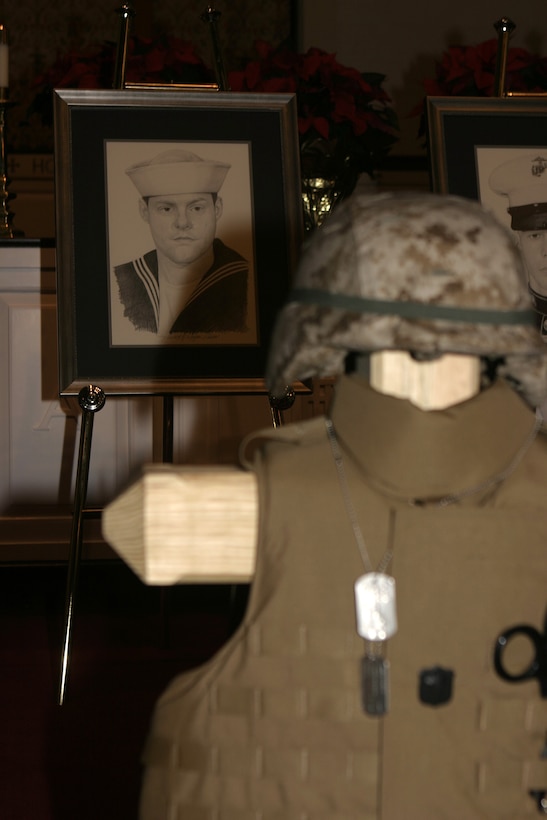 MARINE CORPS BASE CAMP LEJEUNE, N.C. - A black-and-white sketch of 'Doc' Aaron Kent, a corpsman with 1st Battalion, 6th Marine Regiment, rests behind his gear display during a memorial service here Dec. 2.  First Battalion, Sixth Marine Regiment and 2nd CEB personnel had gathered at the Main Protestant Chapel here to commemorate the lives of Kent and Lance Corporals Andrew Kilpela, Mario Castillo and Joshua Klinger.  The four service members were killed by improvised explosive devices during the unit's deployment to Iraq from March through October.
