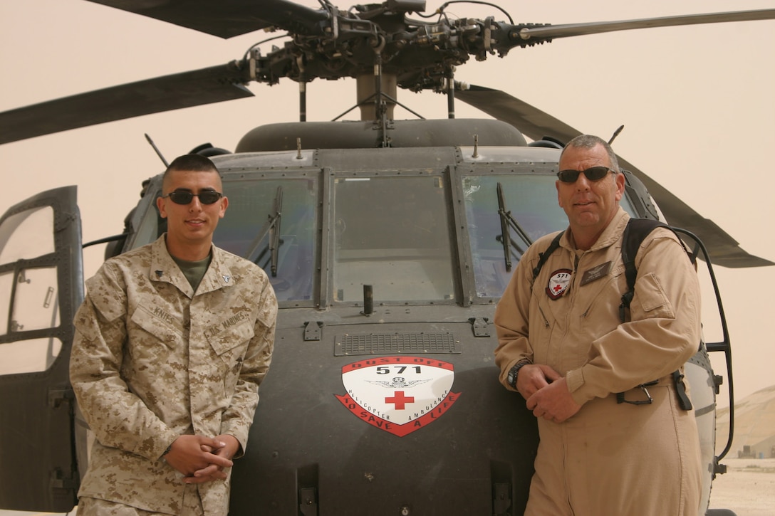 AL ASAD, Iraq- Corporal Will Knies, electrician, Marine All-Weather Fighter Attack Squadron 224 stands next to his father, Chief Warrant Officer Bart Knies, product control officer, 571st Medical Company (Air Ambulance) here. Father and son are serving here with their respective units at the same time.