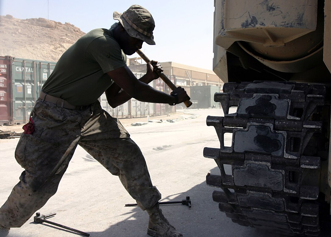 Camp Ripper, Al Anbar, Iraq (Apr i11, 2005)-- 4th AAV crewman attached to 3/25 Lance Cpl. Chimbuoyim Okoli, 23 of Virginia Beach, Va.,  replaces old tracks on this vehicles so it can be reay to carry out it's next missio. (Official USMC Photo by Corporal Ken Melton)
