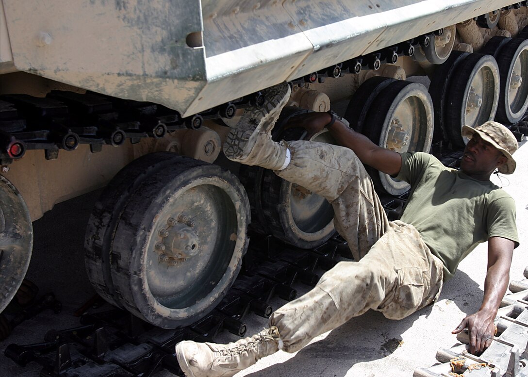 Camp Ripper, Al Anbar, Iraq (Apr i11, 2005)-- 23-year-old Lance Cpl. Chimbuoyim Okoli a 4th AAV crewman attached to 3/25 ,pushes the new track on this vehiclesso it can be reay to carry out it's next missio. (Official USMC Photo by Corporal Ken Melton)