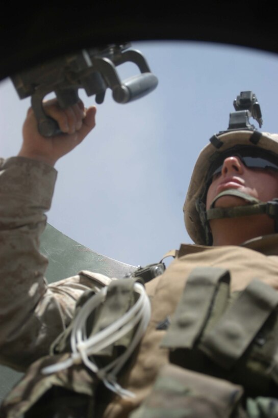 AR RAMADI, Iraq (April 2, 2005) - Twenty-two-year-old Salt Lake City native Cpl. Donald W. Ball, team leader, 3rd Squad, 4th Platoon, Company B, 1st Battalion, 5th Marines, sits in the turret of a Humvee and provides security while he and his fellow Marines travel through the city here. Marines with 4th Platoon, Company B, 1st Battalion, 5th Marine Regiment and leathernecks of Company A, 1st Combat Engineer Battalion teamed up and discovered four 120 mm shells, a 155 mm shell; several live and empty 7.62 rounds, explosive detonation cord, a live fragmenting grenade and one rocket launcher during a five-hour search conducted on several acres of farmland along the banks of the Euphrates River on the edge of the city. Photo by Cpl. Tom Sloan