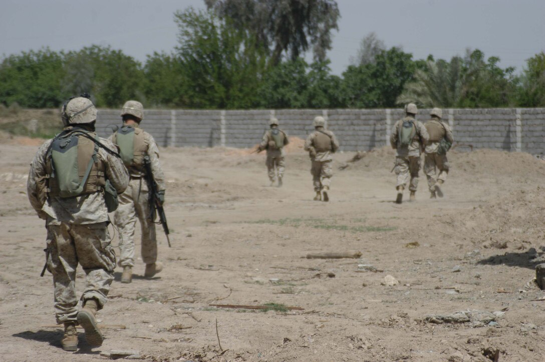 AR RAMADI, Iraq (April 2, 2005) - Marines with 4th Platoon, Company B, 1st Battalion, 5th Marines, patrol an area on the outskirts of the city here during a weapons caches search. Marines with 4th Platoon, Company B, 1st Battalion, 5th Marine Regiment and leathernecks of Company A, 1st Combat Engineer Battalion teamed up and discovered four 120 mm shells, a 155 mm shell; several live and empty 7.62 rounds, explosive detonation cord, a live fragmenting grenade and one rocket launcher during a five-hour search conducted on several acres of farmland along the banks of the Euphrates River on the edge of the city. Photo by Cpl. Tom Sloan