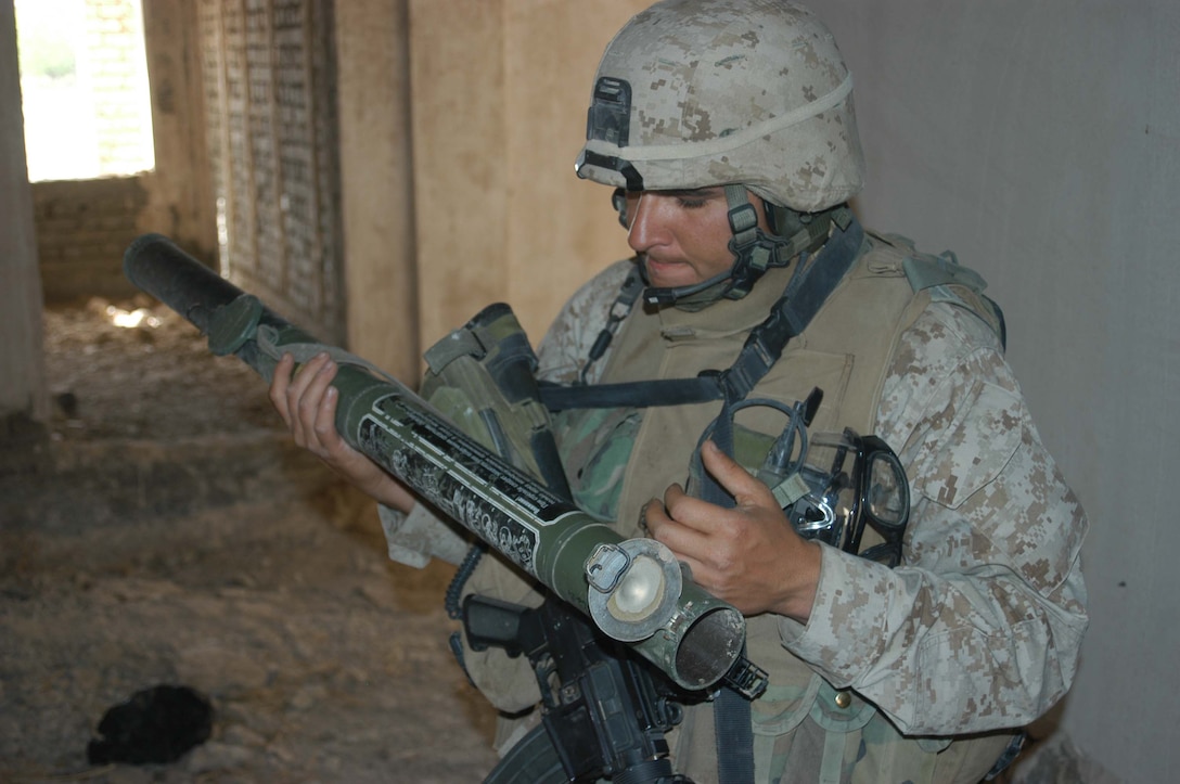 AR RAMADI, Iraq (April 2, 2005) - Gunnery Sgt. Walter G Siquieros, platoon sergeant, 4th Platoon, Company B, 1st Battalion, 5th Marines, 31, of Calexico, Calif., examines a rocket launcher he found in an abandoned warehouse on the outskirts of the city here where he and his fellow Marines conducted a weapons cashes search. Marines with 4th Platoon, Company B, 1st Battalion, 5th Marine Regiment and leathernecks of Company A, 1st Combat Engineer Battalion teamed up and discovered four 120 mm shells, a 155 mm shell; several live and empty 7.62 rounds, explosive detonation cord, a live fragmenting grenade and one rocket launcher during a five-hour search conducted on several acres of farmland along the banks of the Euphrates River on the edge of the city. Photo by Cpl. Tom Sloan