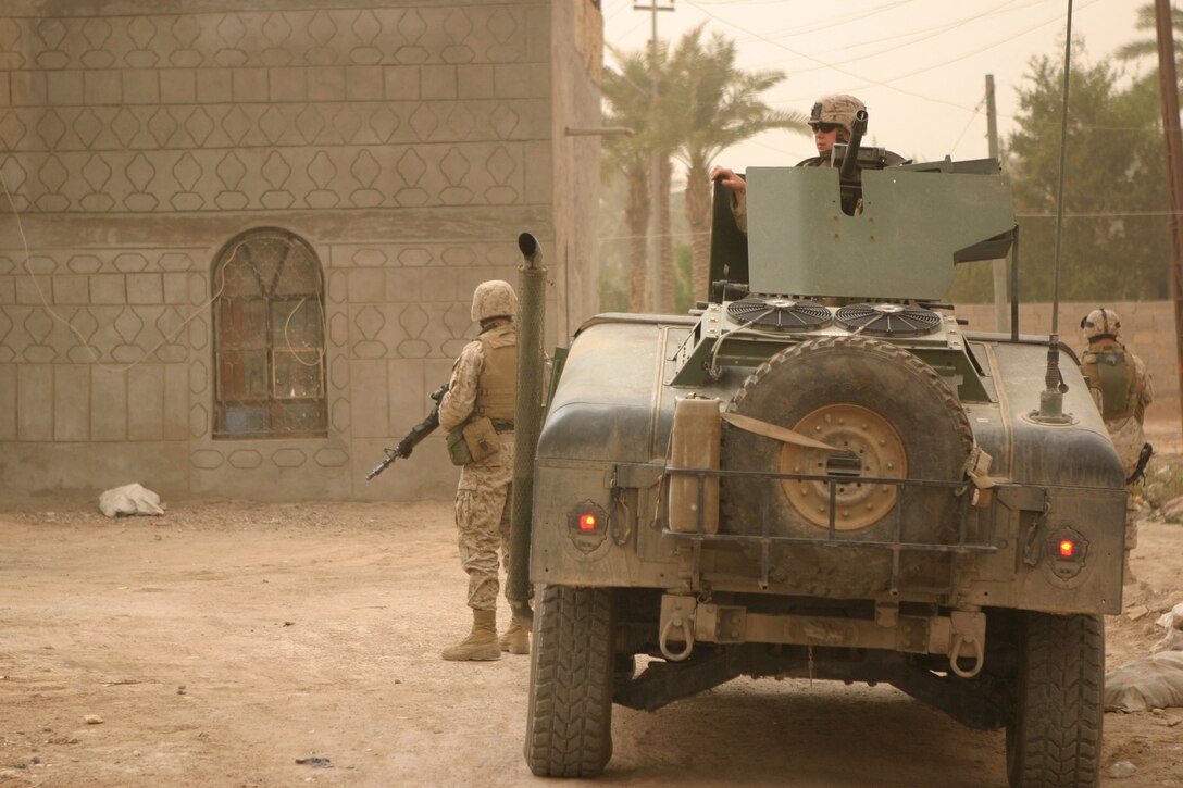 AR RAMADI, Iraq -- Marines with Camp Blue Diamond's quick reaction force guard their convoy as other members of their team hand out stuffed animals and soccer balls to Iraqi children, April 3.  U.S. Marine Corps photo by Sgt. Stephen D'Alessio (RELEASED)