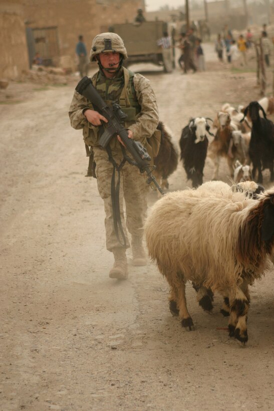 AR RAMADI, Iraq -- Lance Corporal Isaiah Schaeffer, a 20-year-old team leader in 3rd squad, patrols the town as the rest of the Marines with Camp Blue Diamond's quick reaction force hand out stuffed animals and soccer balls to Iraqi children, April 3.  Schaeffer is a Fredericksburg, Va. native and 2002 graduate of Chancellor High School.  U.S. Marine Corps photo by Sgt. Stephen D'Alessio (RELEASED)