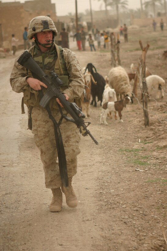 AR RAMADI, Iraq -- Lance Corporal Isaiah Schaeffer, a 20-year-old team leader in 3rd squad, patrols the town as the rest of Camp Blue Diamond's quick reaction force hand out stuffed animals and soccer balls to Iraqi children, April 3.  Schaeffer is a Fredericksburg, Va. native and 2002 graduate of Chancellor High School.  U.S. Marine Corps photo by Sgt. Stephen D'Alessio (RELEASED)