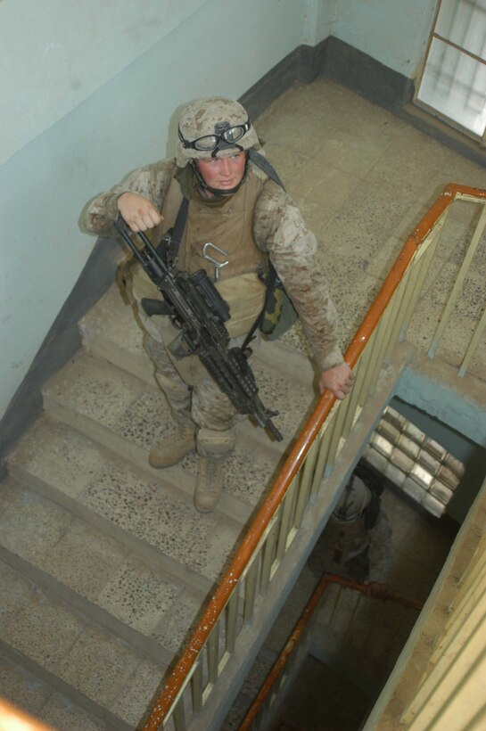 AR RAMADI, Iraq (April 24, 2005) - Lance Cpl. Jesse H. McClellan, a squad automatic machine gunner with 2nd Squad, 3rd Platoon, Company A, 1st Battalion, 5th Marine Regiment, keeps a vigilant eye on the floor above him while securing a portion of a stairwell to a four-story apartment complex in the city here he and his Marines are searching. The 20-year-old from Borger, Texas, and his fellow 3rd Platoon warriors cordoned off a two-block radius of Company A's area of operations and conducted a detailed search of its buildings and residents. The Marines didn't encounter any insurgents or threats during their three-hour-mission and returned safely to their firm base at Camp Hurricane Point without incident. Photo by Cpl. Tom Sloan