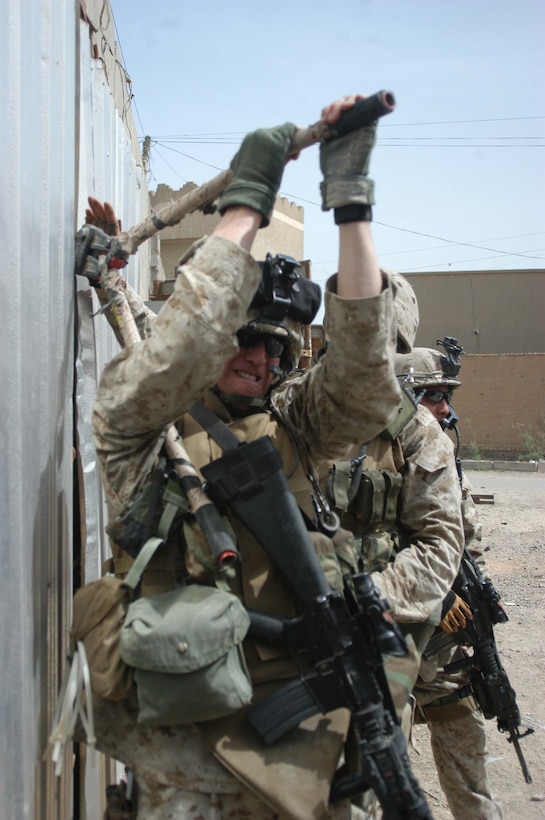 AR RAMADI, Iraq (April 24, 2005) - Corporal Troy C. Arnold, squad leader and rifleman with 2nd Squad, 3rd Platoon, Company A, 1st Battalion, 5th Marine Regiment, grits his teeth as he strains to cut a lock securing a storage building in the city here he and his Marines need to search. The 27-year-old from Knoxville, Tenn., and his fellow 3rd Platoon warriors cordoned off a two-block radius of Company A's area of operations and conducted a detailed search of its buildings and residents. The Marines didn't encounter any insurgents or threats during their three-hour-mission and returned safely to their firm base at Camp Hurricane Point without incident. Photo by Cpl. Tom Sloan