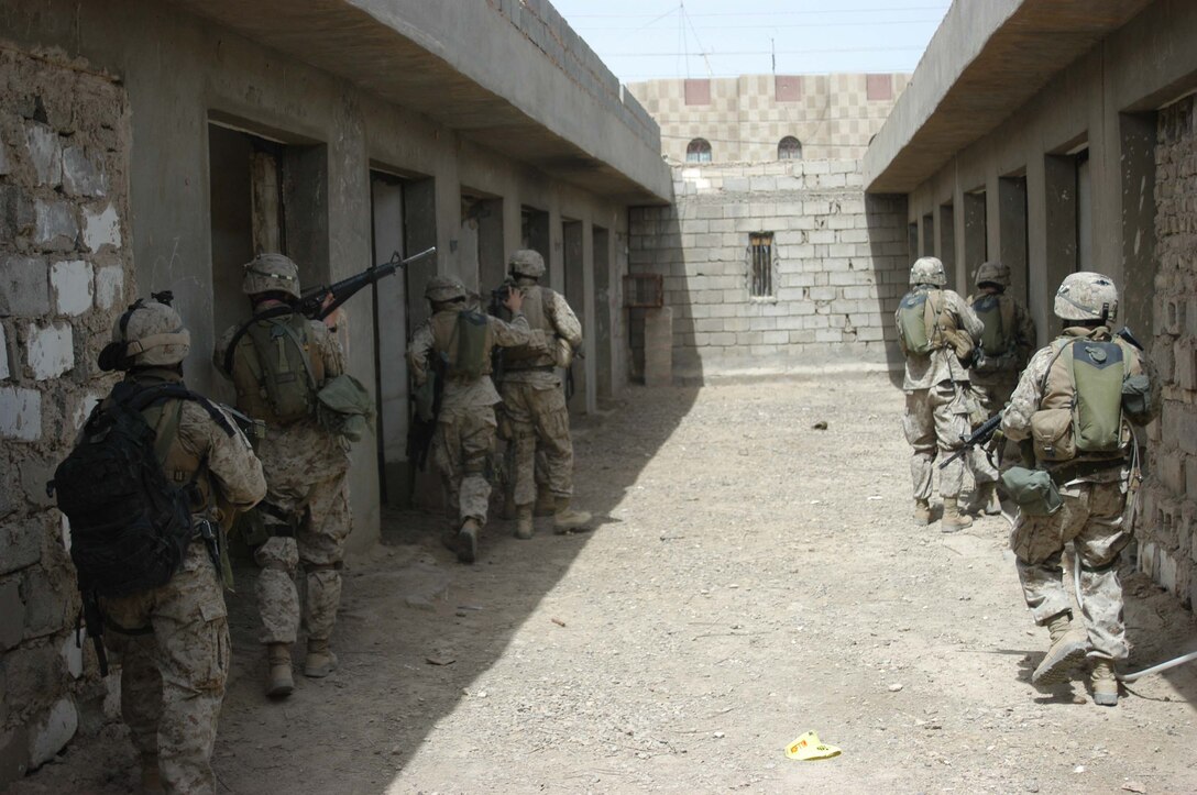AR RAMADI, Iraq (April 24, 2005) - Marines with 3rd Platoon, Company A, 1st Battalion, 5th Marine Regiment, stick close to the walls as they search a storage complex in the city here. The warriors cordoned off a two-block radius of Company A's area of operations and conducted a detailed search of its buildings and residents. The Marines didn't encounter any insurgents or threats during their three-hour-mission and returned safely to their firm base at Camp Hurricane Point without incident. Photo by Cpl. Tom Sloan