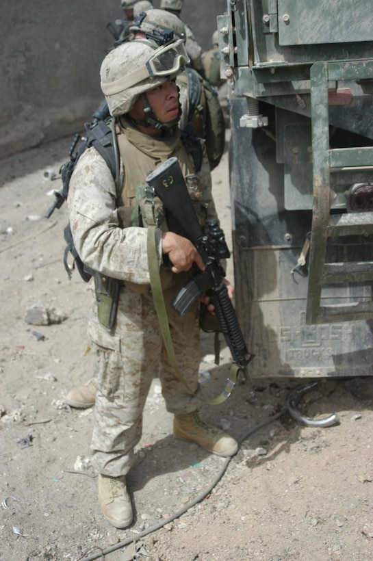 AR RAMADI, Iraq (April 24, 2005) - Lance Cpl. Mario R. De la Rosa, a rifleman with 2nd Squad, 3rd Platoon, Company A, 1st Battalion, 5th Marine Regiment, provides security for his Marines from the rear of a 7-ton truck parked on street in the city here. The 20-year-old from San Francisco and his fellow 3rd Platoon warriors cordoned off a two-block radius of Company A's area of operations and conducted a detailed search of its buildings and residents. The Marines didn't encounter any insurgents or threats during their three-hour-mission and returned safely to their firm base at Camp Hurricane Point without incident. Photo by Cpl. Tom Sloan