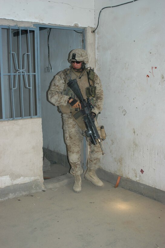 AR RAMADI, Iraq (April 24, 2005) - Corporal Christopher A. Hook, a rifleman and team leader with 2nd Squad, 3rd Platoon, Company A, 1st Battalion, 5th Marine Regiment, searches a room in an abandoned building in the city here. The 26-year-old from Chelsea, Va., and his fellow 3rd Platoon warriors cordoned off a two-block radius of Company A's area of operations and conducted a detailed search of its buildings and residents. The Marines didn't encounter any insurgents or threats during their three-hour-mission and returned safely to their firm base at Camp Hurricane Point without incident. Photo by Cpl. Tom Sloan