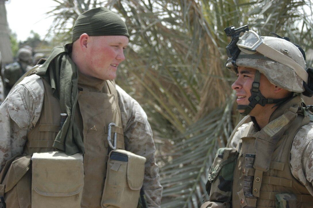 CAMP HURRICANE POINT Ar Ramadi, Iraq (April 24, 2005) - Marines are known for their ability to adapt and overcome. Lance Cpl. Jesse H. McClellan, a squad automatic machine gunner with 2nd Squad, 3rd Platoon, Company A, 1st Battalion, 5th Marine Regiment, uses an undershirt to keep sweat out of his eyes while he patrols the city's streets for hours on end with his fellow Marines. The 20-year-old from Borger, Texas, jokes with his comrade, Lance Cpl. Mario R. De la Rosa, a rifleman with 2nd Squad, 3rd Platoon, Company A, before loading up and heading out into the city on another mission. Photo by Cpl. Tom Sloan