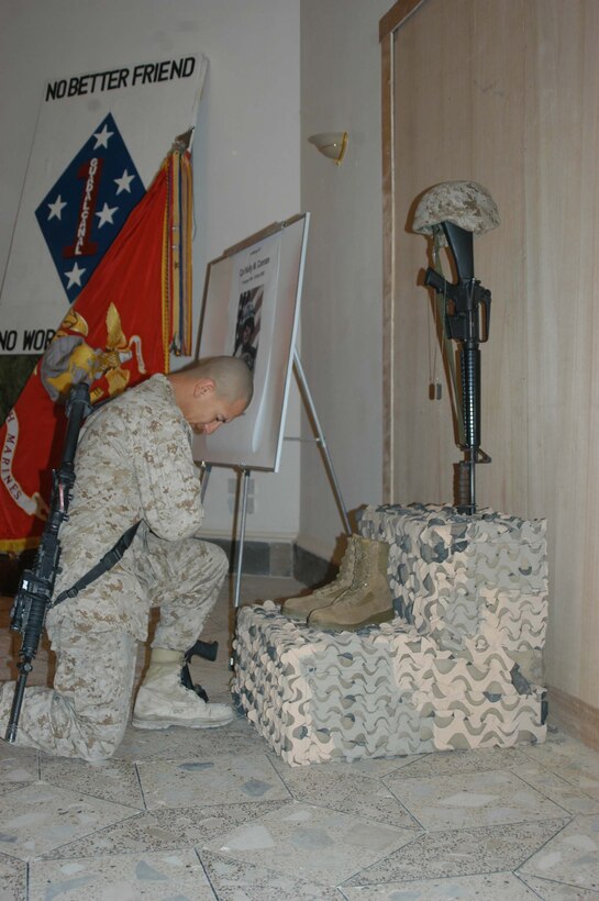 CAMP HURRICANE POINT, Ar Ramadi, Iraq (April 25, 2005) - Lance Cpl. Manuel Valle Jr., team leader, 2nd Squad, 1st Platoon, Company A, 1st Battalion, 5th Marine Regiment, takes a knee in front of a warrior's memorial and pays his final respects for his fellow comrade, Cpl. Kelly M. Cannan, who fell on the battlefield here April 20. Marines with 1st Battalion, 5th Marine Regiment, held a dual memorial ceremony in honor of Cannan, 21, of Lowville, N.Y., and Lance Cpl. Marty G. Mortenson, 22, of Flagstaff, Ariz. Both warriors were killed by the same improvised explosive device attack while traveling in a convoy. They were on their third deployment supporting Operation Iraqi Freedom. Photo by Cpl. Tom Sloan