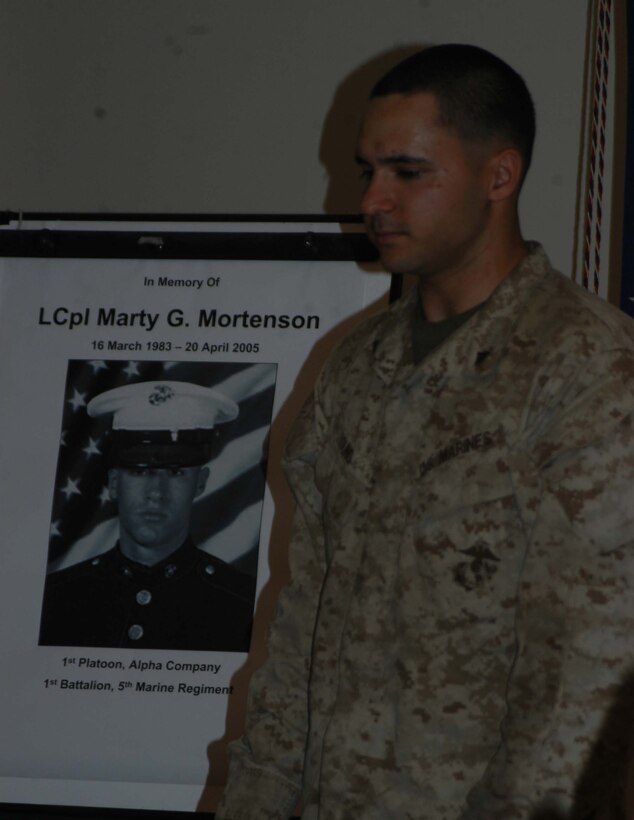 CAMP HURRICANE POINT, Ar Ramadi, Iraq (April 25, 2005) - Lance Cpl. Eric J. Young, a rifleman with 1st Platoon, Company A, 1st Battalion, 5th Marine Regiment, stands in front of a photo of his comrade, Lance Cpl. Marty G. Mortenson, and tells what type of person his friend was to the Marines attending the memorial ceremony here. Marines with 1st Battalion, 5th Marine Regiment, held a dual memorial ceremony in honor of Mortenson, 22, of Flagstaff, Ariz., and Cpl. Kelly M. Cannan, 21, of Lowville, N.Y. Both warriors were killed by the same improvised explosive device attack while traveling in a convoy April 20. They were on their third deployment supporting Operation Iraqi Freedom. Photo by Cpl. Tom Sloan