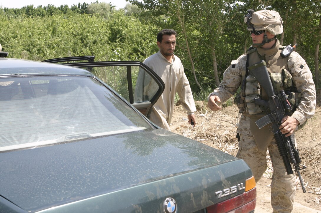 SAQLAWIYAH, Iraq - Pfc. Eric Gunderson, a rifleman with 2nd Platoon, Company A, 1st Battalion, 6th Marine Regiment, prepares to search an Iraqi man's vehicle here April 27.  The 22-year-old Madelia, Minn. native and his unit are currently working with the local security forces to search for illegal weapons and root out remaining insurgents.
