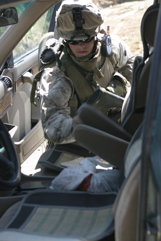 SAQLAWIYAH, Iraq - Pfc. Eric Gunderson, a rifleman with 2nd Platoon, Company A, 1st Battalion, 6th Marine Regiment, searches an Iraqi man's vehicle here April 27.  The 22-year-old Madelia, Minn. native and his unit are currently working with the local security forces to search for illegal weapons and root out remaining insurgents.
