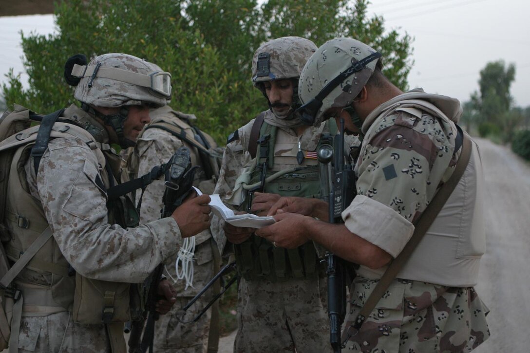 CAMP DELTA, IRAQ -- As Marines move through the city of Al Karmah, they look through a list of names to see if the man they detained was on it.  Predetermined targets were put together in a list for the Marines as they hit targeted houses around the area.  Official U.S. Marine Corps photo by Lance Cpl. Athanasios L. Genos