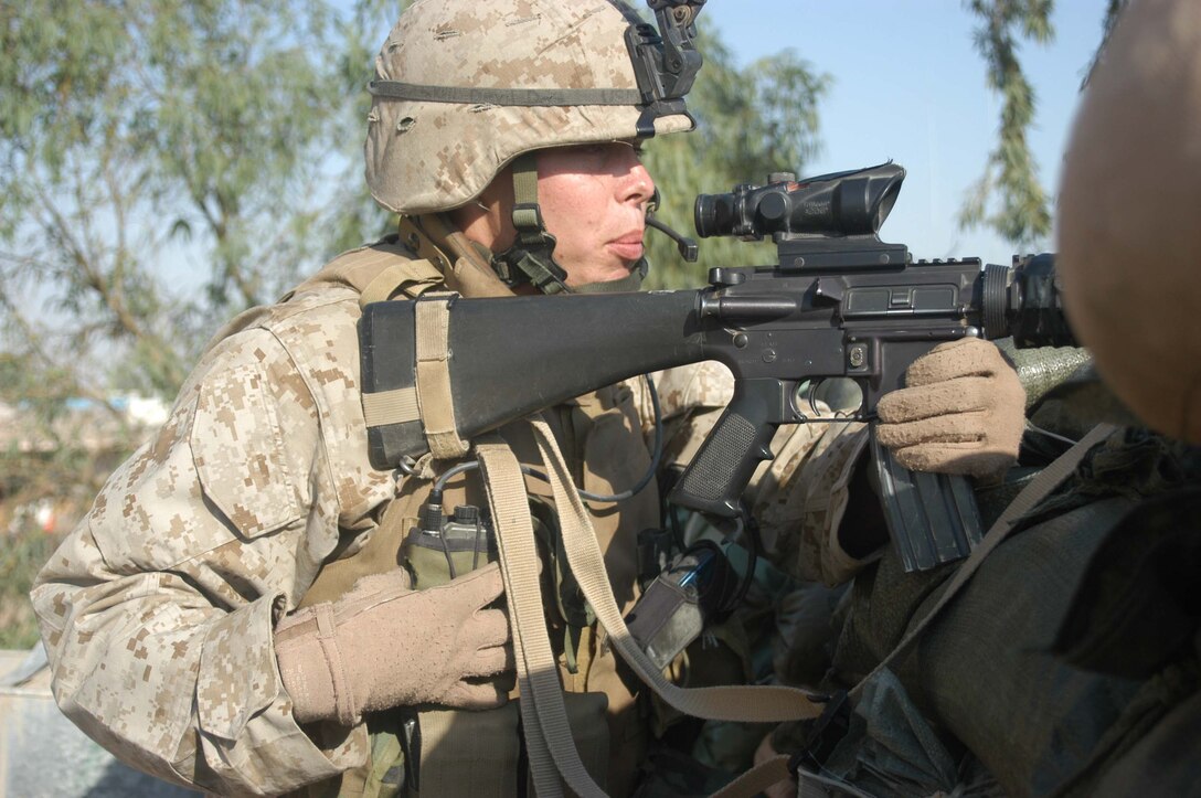 CAMP SNAKE PIT Ar Ramadi, Iraq (May 3, 2005) -- Sergeant Seth D. Hickman, squad leader of 1st Squad, 2nd Platoon, Company C, 1st Battalion, 5th Marine Regiment, communicates with his fellow Marines on his radio while looking for insurgents who've been engaging the Marines here with sporadic gunfire. The Mason City, Iowa, native celebrated part of his 24th birthday on the top of his Company C's command operations center building engaging insurgents with his weapon. Insurgents attacked the company's firm base with small arms fire a few minutes past 8 a.m.The warriors successfully defended their camp from the attack and fought of the terrorists. Photo by Cpl. Tom Sloan