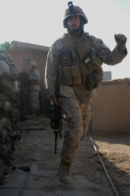 CAMP SNAKE PIT Ar Ramadi, Iraq (May 3, 2005) -- Sergeant Seth D. Hickman, squad leader of 1st Squad, 2nd Platoon, Company C, 1st Battalion, 5th Marine Regiment, moves about the rooftop of the Company C's command operations center building and issues orders to his Marines while taking sporadic gunfire from insurgents here. The Mason City, Iowa, native celebrated part of his 24th birthday on the COC rooftop engaging insurgents with his weapon. Insurgents attacked the company's firm base with small arms fire a few minutes past 8 a.m. The warriors successfully defended their camp from the attack and fought of the terrorists. Photo by Cpl. Tom Sloan