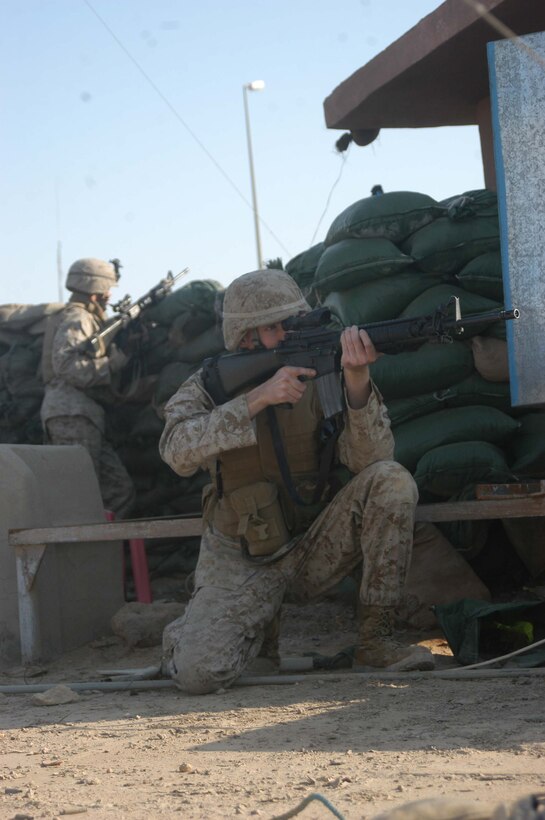 CAMP SNAKE PIT Ar Ramadi, Iraq (May 3, 2005) -- Lance Cpl. Eric S. Johnson, armorer with Company C, 1st Battalion, 5th Marine Regiment, takes a knee and posts security from the rooftop of the command operations center building here while being attacked by insurgents. The 21-year-old from Vincennes, Calif., and other Company C Marines were attacked by insurgents few minutes past 8 a.m.The warriors successfully defended their camp from the attack and fought of the terrorists. Photo by Cpl. Tom Sloan