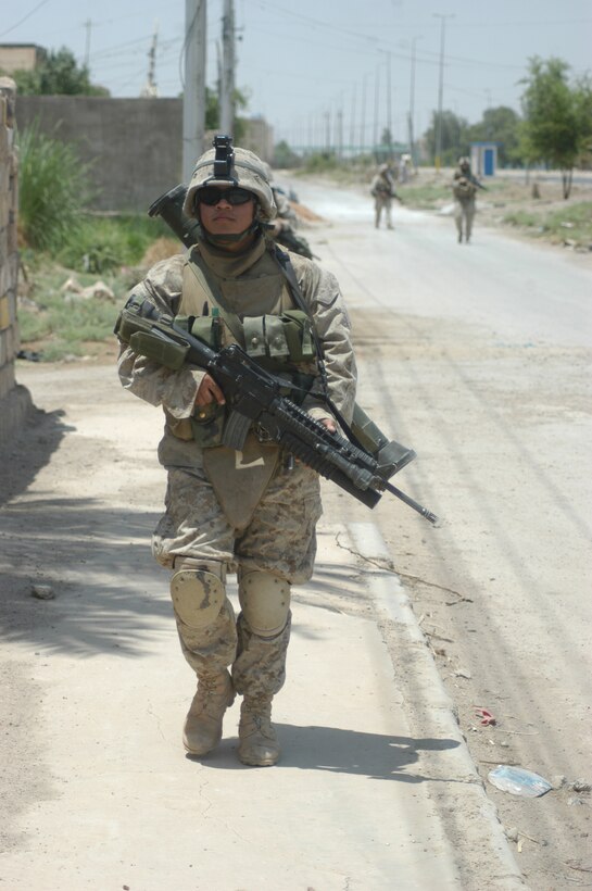 AR RAMADI Iraq (June 3, 2005) - Lance Cpl. Darvy L. Perez, an assault man with 1st Squad, 2nd Platoon, Company C, 1st Battalion, 5th Marine Regiment, patrols down a street here during a mission. The 20-year-old from Chicago, his fellow 1st Squad warriors and seven members of the Iraqi Security Forces conducted a mission to listen to messages a mosque was broadcasting over its loudspeakers during midday prayer. Photo by: Cpl. Tom Sloan