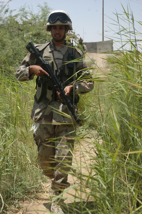 AR RAMADI Iraq (June 3, 2005) - An Iraqi Security Force member negotiates his way along a dirt path during a mission here. Seven members of the ISF accompanied Marines with 1st Squad, 2nd Platoon, Company C, 1st Battalion, 5th Marine Regiment, and, together, conducted a mission to listen to messages a mosque was broadcasting over its loudspeakers during midday prayer. Marines with Company C are having a positive influence on the locals in their area of operations by working with the ISF. Photo by: Cpl. Tom Sloan