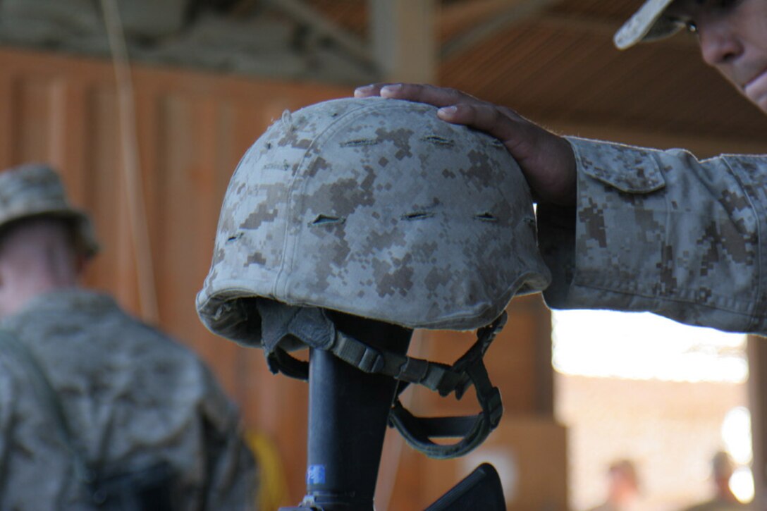 051103-M-2607-014 - The Marines of the battalion show their respect to the fallen Marines and sailor by placing their hand on top of the Kevlar following the memorial service on Nov 3.