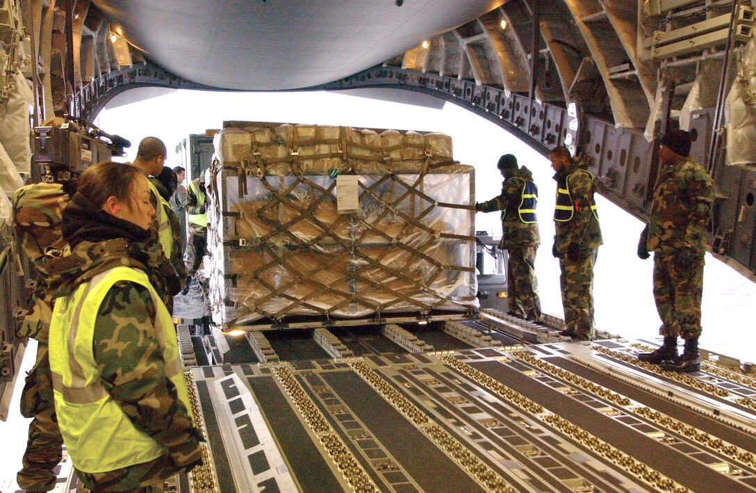 YOKOTA AIR BASE, Japan -- Airmen from the 374th Airlift Wing load supplies onto a C-17 Globemaster III here Dec. 31.  The aircraft is headed for a forward-operating base in Utapao, Thailand.  The supplies are intended to help other Airmen conduct missions supporting tsunami relief efforts in Thailand, Indonesia, Sri Lanka and India.  About 170 Airmen from here have also deployed to support relief operations throughout the region. (U.S. Air Force photo by 1st Lt. Warren Comer)