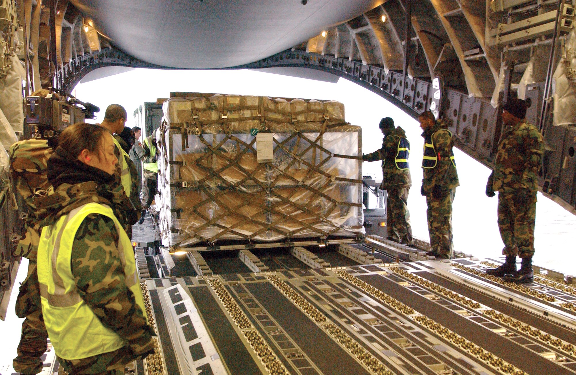 YOKOTA AIR BASE, Japan -- Airmen from the 374th Airlift Wing load supplies onto a C-17 Globemaster III here Dec. 31.  The aircraft is headed for a forward-operating base in Utapao, Thailand.  The supplies are intended to help other Airmen conduct missions supporting tsunami relief efforts in Thailand, Indonesia, Sri Lanka and India.  About 170 Airmen from here have also deployed to support relief operations throughout the region. (U.S. Air Force photo by 1st Lt. Warren Comer)