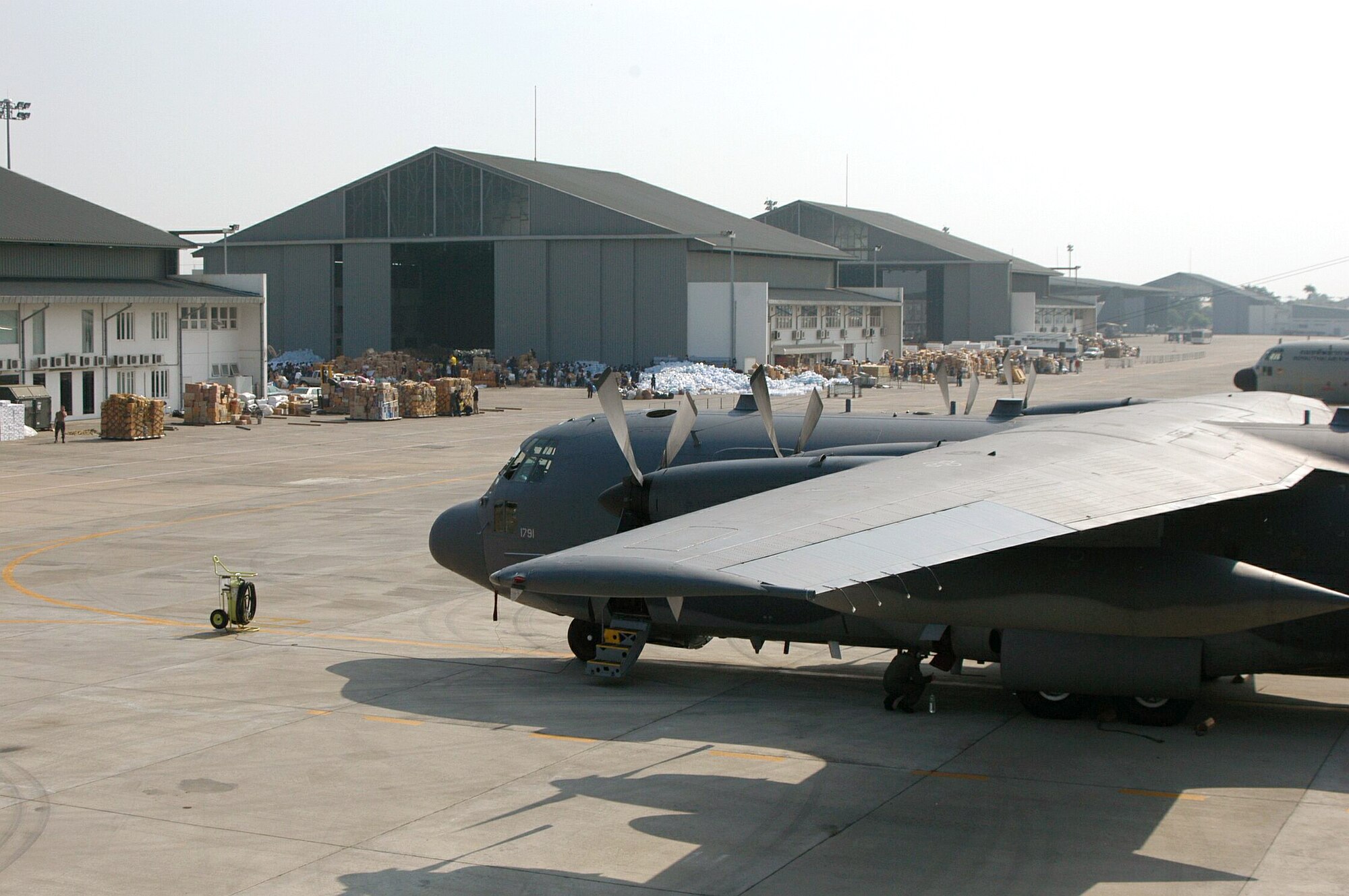 BANGKOK, Thailand -- An MC-130 from Kadena Air Base, Japan, awaits loading in front of a Royal Thai air force hangar here that has become the relief donation center for the kingdom.  (U.S. Air Force photo by Master Sgt. Michael Farris)